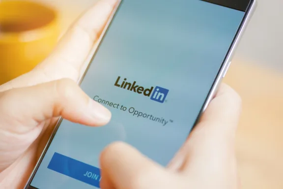 Person holding a phone with LinkedIn displaying